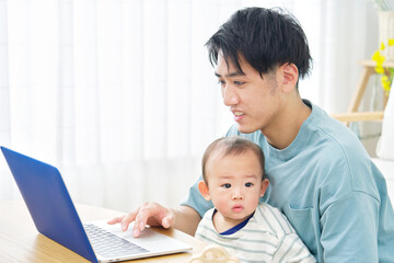 Fototapeta na wymiar 父親と赤ちゃん　パソコン　リビング