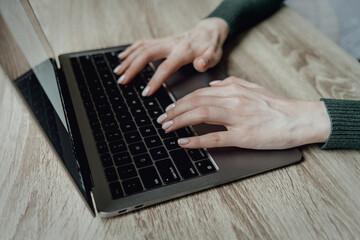 The hands of a young girl are typing in a laptop. Workspace work at home. Online business and freelancing. Distance learning. Work with numbers and text. High quality photo