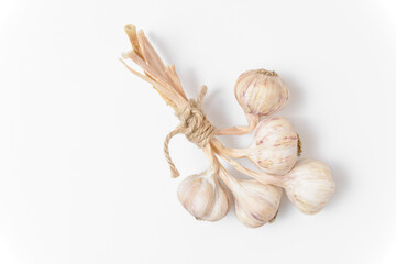 A bunch of five garlic tied with twine on a white background. Close up top view.