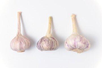 Three fresh garlic lie on a white background. Close up top view.