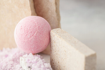 Sea colored salt and bath ball on a stone podium. Spa cosmetics concept