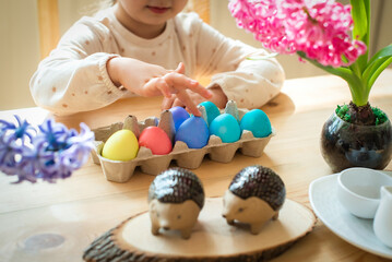 a little cute girl paints Easter eggs. spring flowers hyacinths, colorful eggs - holiday decoration