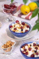 Blue bowl of cottage cheese with berries, honey and nuts for breakfast, selective focus.