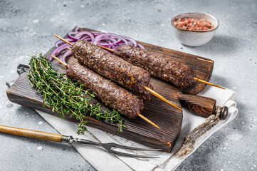 Grilled kofta kofte shish kebab from mince lamb and beef meat on Skewer. Gray background. Top view