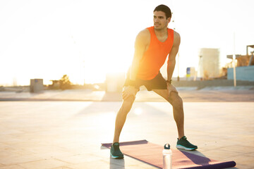 Young muscle man training outside. Fit handsome man doing exercise..