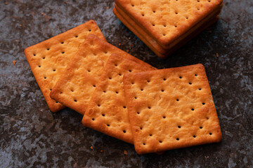 close up cream crackers on dirty metal sheet backdrop. delicious crackers snack.