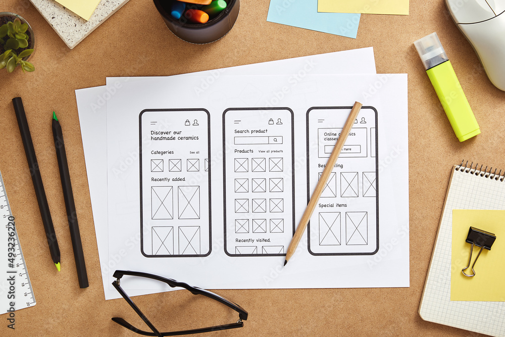 Poster busy web ux designer desk with mobile app wireframe sketches and office supplies. flat lay.