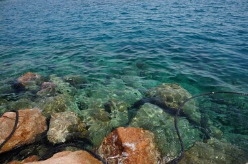Clear sea water surface, stones and glare