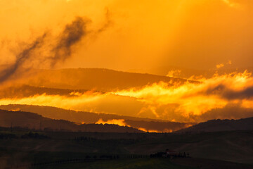 Scenic sunset over rolling hills in silhouette