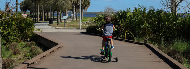 Kissimmee Lakefront Park Grassy waterfront park with walking paths, a fishing pier, picnic pavilions, and a shaded playground. children's playgrounds, splash pad - obrazy, fototapety, plakaty