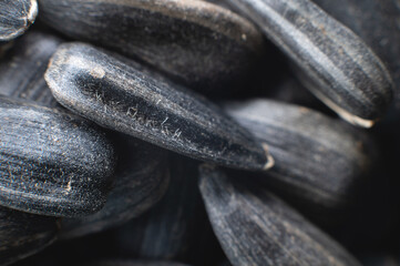 Close-up of black sunflower seeds. texture, background of natural and healthy snacks. Macro photography with shallow depth of field