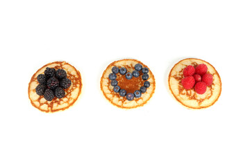 Fototapeta na wymiar Pancakes with red fruits: blueberries, raspberries and blackberries on a white background 