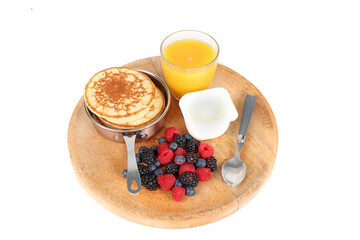 Pancakes with red fruits: blueberries, raspberries and blackberries on a white background 