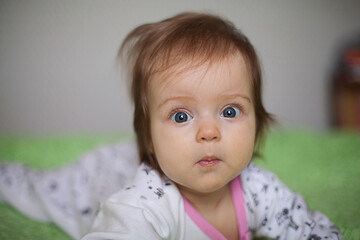 Fototapeta premium Little girl portrait at home. One-year-girl playing on floor