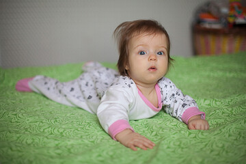 Fototapeta premium Little girl portrait at home. One-year-girl playing on floor