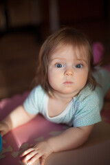Fototapeta na wymiar Little girl portrait at home. One-year-girl playing on floor