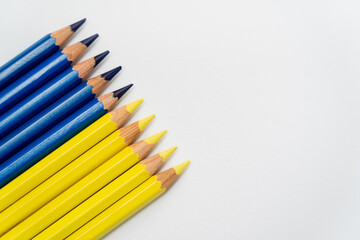 Top view of yellow and blue color pencils on white background with copy space.