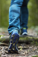 On the trail. Shot of an unidentifiable young man hiking through the forest.