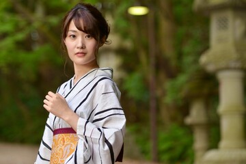 神社の境内にて浴衣を着た微笑む美しい女性のポートレート	