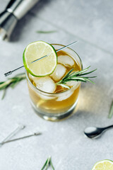 Alcohol cocktail with lime slice rosemary ice and cocktail shaker on black background. Party time