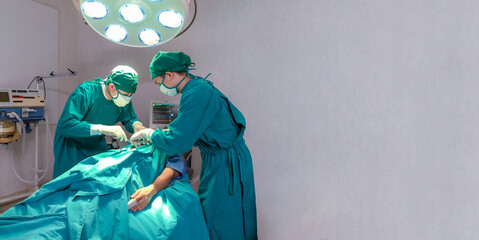 Professional intelligent surgeons standing near the patient and performing an operation. copy space