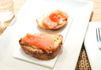 Naklejka na ściany i meble delicious canapes of salted, smoked salmon fillet on slice of fresh ciabatta bread