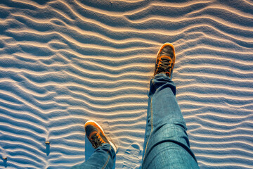 The shoes of a man standing on a sand dune - obrazy, fototapety, plakaty