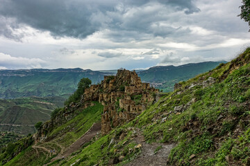 Fototapeta na wymiar Gamsutl village in the Caucasus mountains. Old stone buildings on top of a cliff. Dagestan Russia June 2021