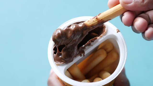 eating breadstick with chocolate spread cream top down 