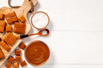 Bowl of caramel sauce and toffee candies with sea salt, top view
