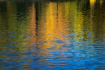 Vivid orange and golden tones reflect in water on an early morning fall day. Northern Wisconsin.