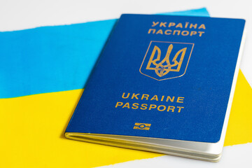 Ukrainian biometric passport on background of Ukrainian flag.  Document for traveling abroad, concept. Isolated on a white background