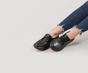 Women's legs in stylish sports shoes on a white background