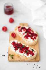 two sandwiches with raspberry jam and curd cheese