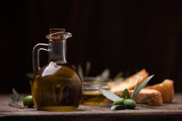 Olive oil with branch on the wooden background