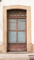 Ventana antigua con persiana rota en fachada de edificio en la calle