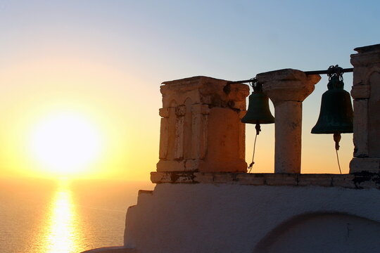 Bells on the sunset with the orange sun over the Mediterranean sea in Greece