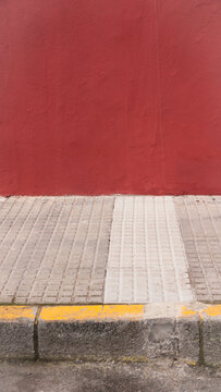 Acera junto a pared pintada de granate