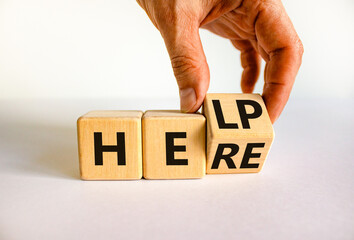 Help is here support symbol. Businessman turns the wooden cube and changes the concept word Help to Here. Beautiful white table white background, copy space. Business support help is here concept.