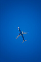 Commercial flight plane against blue sky.