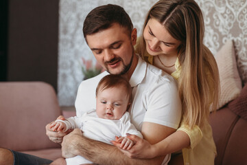 Beautiful young parents holding their cute baby daughter.
