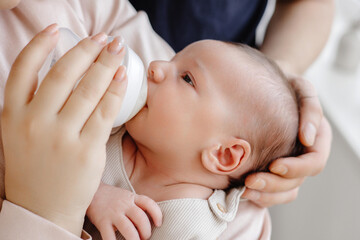 Beautiful baby drinking milk, close up baby drinking milk from baby bottle with mother