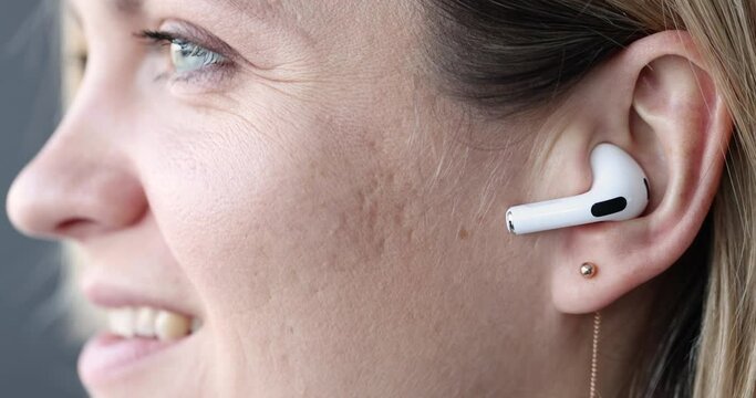 Wireless white bluetooth headphones in female ear