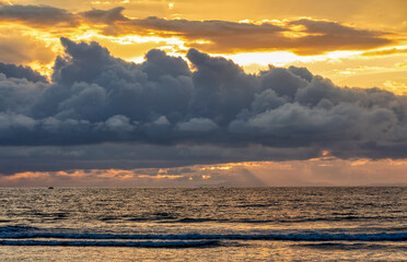 Evening view of the Pacific Coast of Tarcoles in Carara with sunset and glittering waves . Idyllic sunset landscape. Tarcoles, Costa Rica. Pura Vida concept, travel to exotic tropical country.