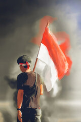Illustration of a man seen from behind holding the Indonesian flag, perfect for the Indonesian Independence Day poster (17 August).