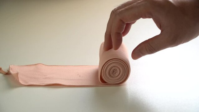 male hand holding a medical bandage roll,Medical bandage roll ,Elastic bandage
