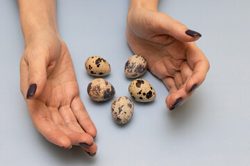 quail eggs lie between the palms of a woman