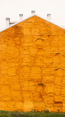 silueta de casa con pared medianera pintada de espuma aislante dorada