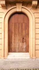 Puerta de madera en arco de fachada monumental