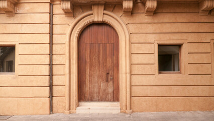 Puerta de madera en arco de fachada monumental